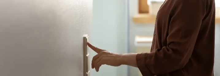 Person betätigt einen Lichtschalter.